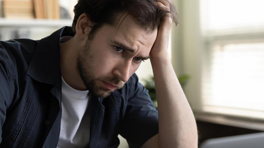 A man sits with a hand resting against his head. This could represent the struggles of dealing with meth abuse in New York, NY. Learn about methamphetamie addiction treatment Manhattan by contacting an online psychiatrist in New York, NY.