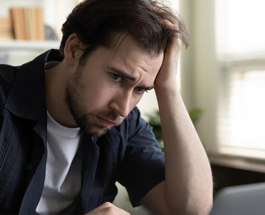 A man sits with a hand resting against his head. This could represent the struggles of dealing with meth abuse in New York, NY. Learn about methamphetamie addiction treatment Manhattan by contacting an online psychiatrist in New York, NY.