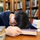 A college students sleeps with their head down while surrounded by books. Learn more about the support a drug addiction therapist in New York, NY can offer by searching for prescription drug addiction treatment in New York, NY today. A psychiatrist in New York, NY can offer support today.