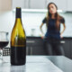 alcohol addition - woman gazes at wine bottle and glass of wine