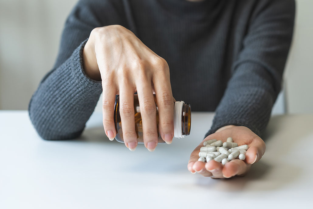 Woman pouring a handful of pills into her hand. Opioid use disorder treatment in New York, NY can hlep you overcome drug abuse. Learn about opioid withdrawal treatment and how opioid addiction and dependence counseling in New York, NY can support you today!