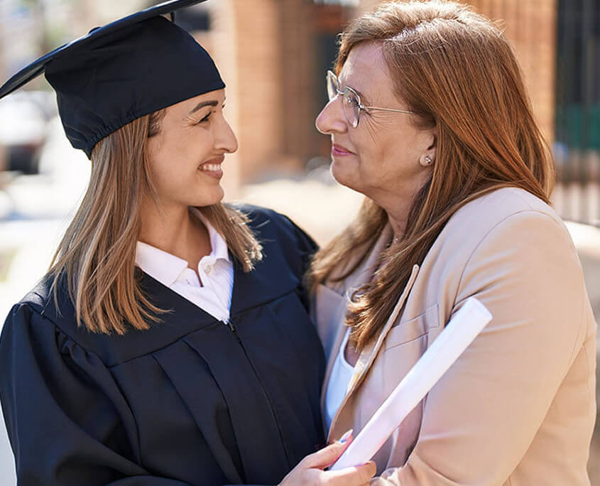 Proud mother hugs young woman graduating college. Psychiatry in New York, NY can offer support with addiction and psychiatric issues. Contact a psychiatrist to learn how online psychiatry in New York, NY can support you from home! 10022