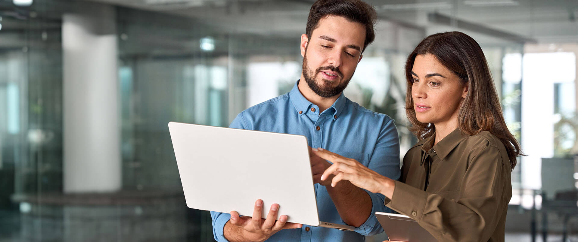 Two professional colleagues work together on a mobile device.