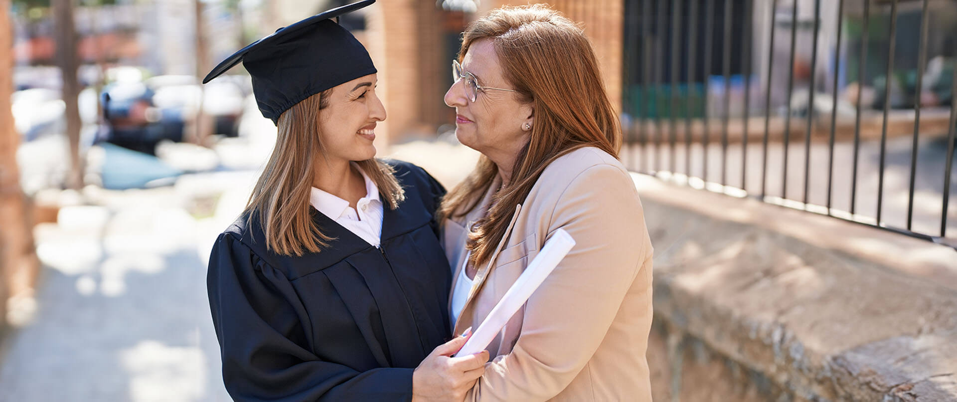 Proud mother hugs young woman graduating college. Psychiatry in New York, NY can offer support with addiction and psychiatric issues. Contact a psychiatrist to learn how online psychiatry in New York, NY can support you from home! 10022