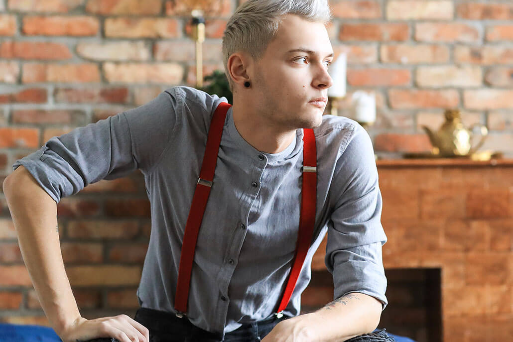 thoughtful young man wearing red suspenders. Young adult psychiatry in New York, NY can offer support with mental health concerns. Contact a teen psychiatrist in New York, NY to learn more about teenage psychiatry today! 10022
