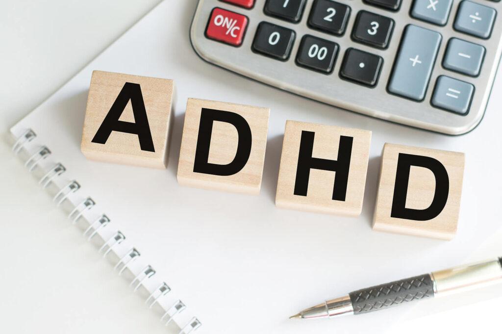 A close-up of a notepad, pen, calculator, and the letters ADHD. Learn how an adult psychiatrist in New York, NY can offer support with alcohol addiction treatment in New York, NY. Search for alcohol addiction help in New York, NY today.
