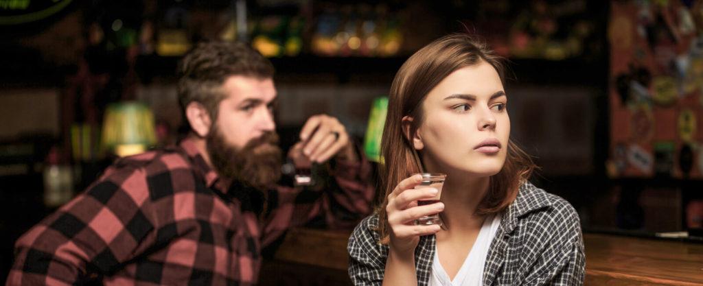 A woman looks away from a man as she drinks a shot at a bar. Alcohol addiction treatment in New York, NY can offer support for issues with drinking. Learn more about alcohol addiction help in New York, NY and other services by contacting a psychiatrist in New York, NY. 10022