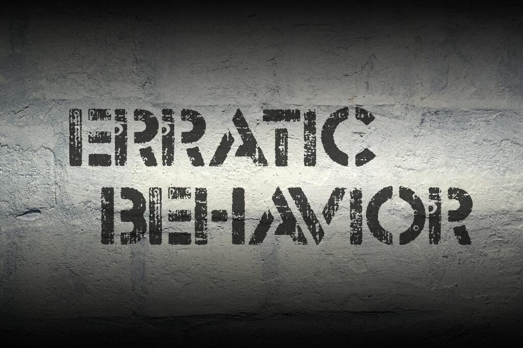 Text is printed on a concrete wall reading “erratic behavior”, representing a symptom of addiction. Learn how an addiction therapist in New York, NY can offer support with outpatient addiction treatment in New York, NY and other services. 
