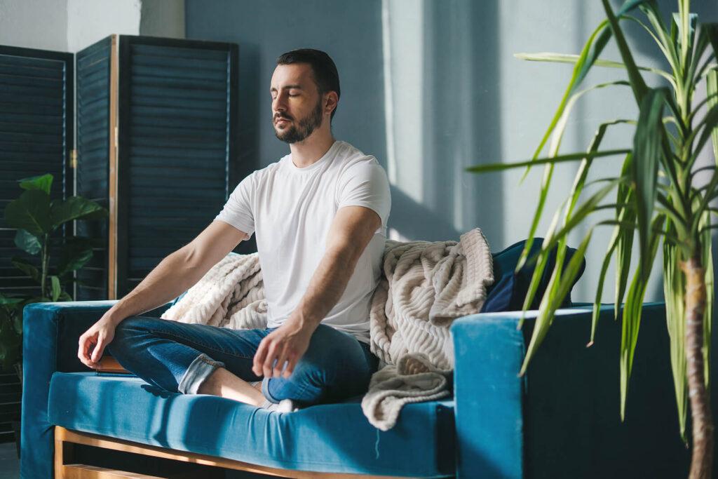 A man sits with his eyes closed while sittting at a sofa. This could represent the benefits of mindfulness that an online psychiatrist in New York, NY can help cultivate. Learn more about addiction treatment in New York, NY and other services today. 
