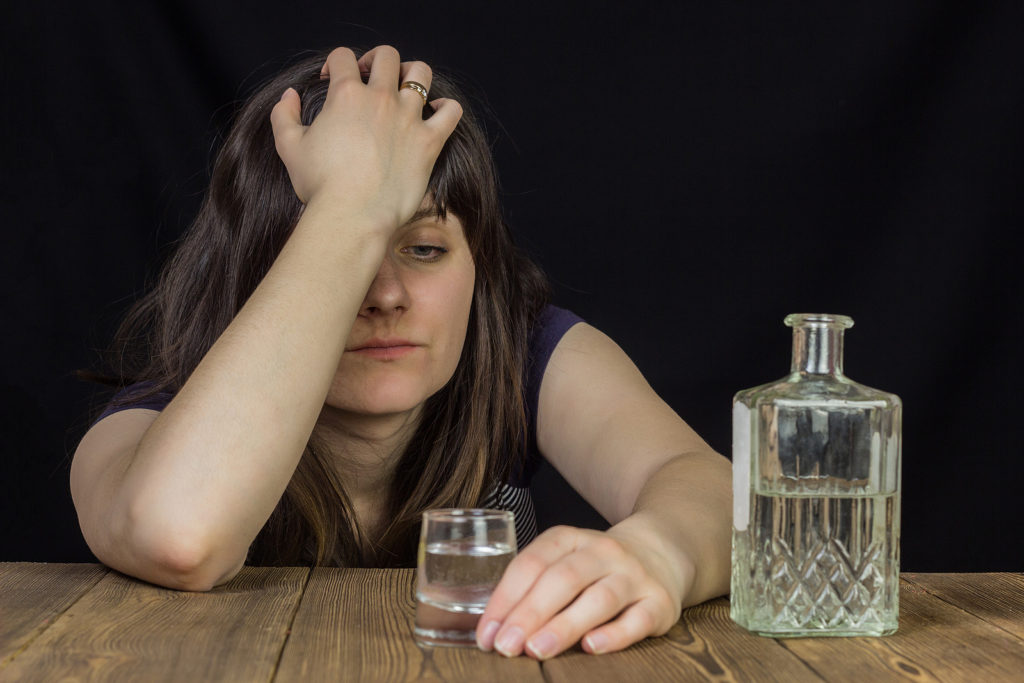 A tired looking woman sits looking at the shot glass in front of her. Young adult psychiatry in New York, NY can offer support with substance abuse treatment in New York, NY and other services. Learn more by contacting a psychiatrist in New York, NY or search psychiatrist for young adults in New York, NY today.
