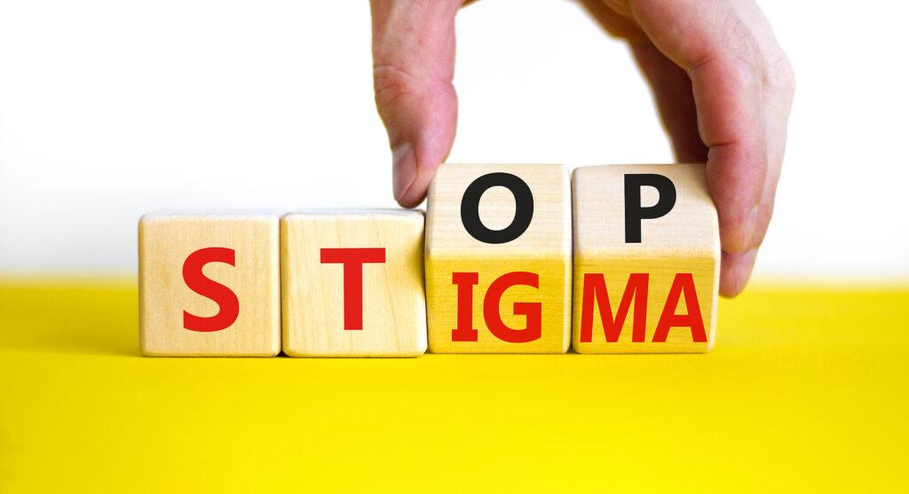 A close up of a person lifting letter blocks showing the words "stop stigma". Learn how a drug addiction therapist in New York, NY can offer support with alcohol addiction treatment in New York, NY. Learn how to overcome the stigma of addiction with an addiction therapist in New York, NY. 
