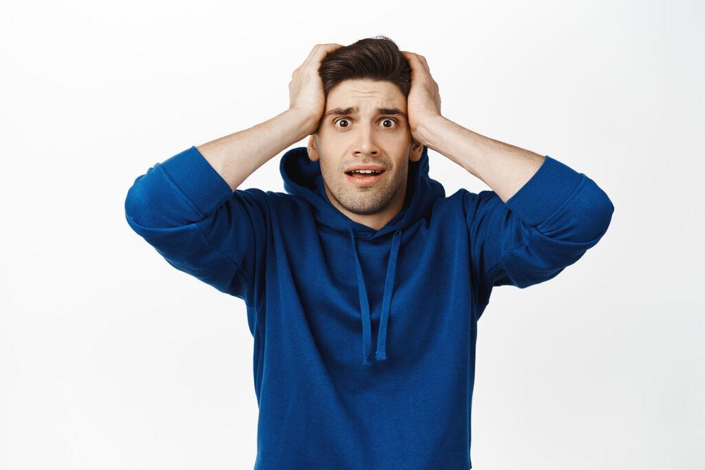 A man holds both sides of his head while looking at the screen with a surprised expression. This could symbolize the fear that alcohol addiction help in New York, NY can help you overcome. Learn more about alcohol treatment in New York, NY can offer support and how to start substance abuse treatment in new york, NY.
