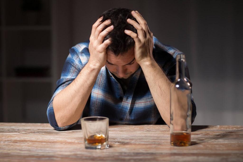 A man holds his head as he struggles to avoid drinking the shot in front of him. Alcohol addiction treatment in New York, NY can offer alcohol addiction help in New York, NY. Contact an online psychiatrist in New York, NY today! 10022
