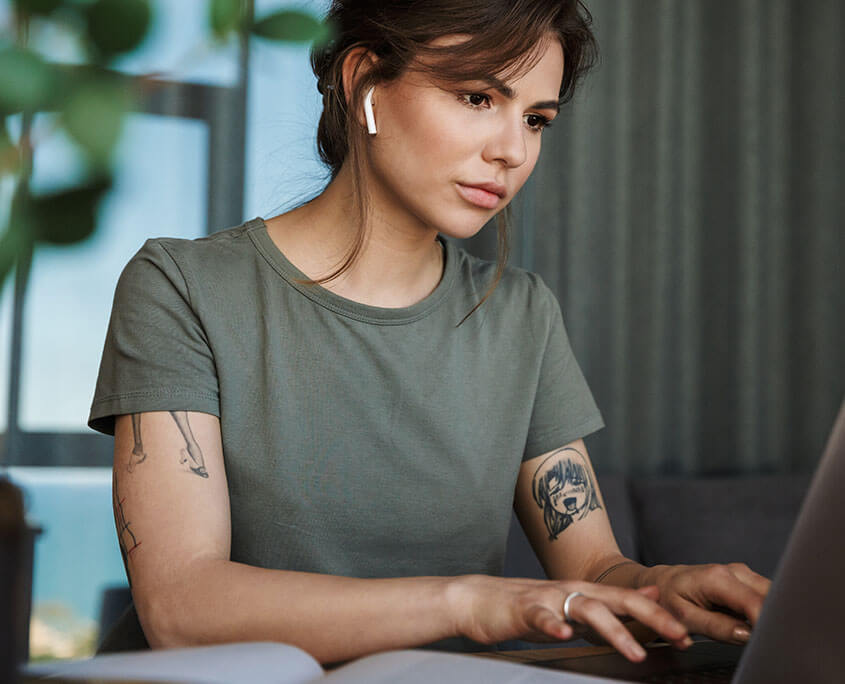 Thoughtful young woman focused on her laptop